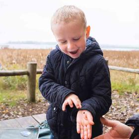 Dreng med mariehøne på Gyldensteen Strand om efteråret